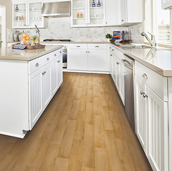 Bright white kitchen with an island and light wood plank flooring.
