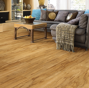 Living room with a grey sectional couch and warm wood-look vinyl plank flooring.