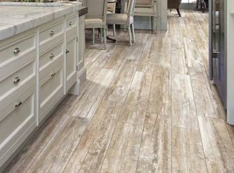 Wood-look ceramic floor tile planks in a bright kitchen.